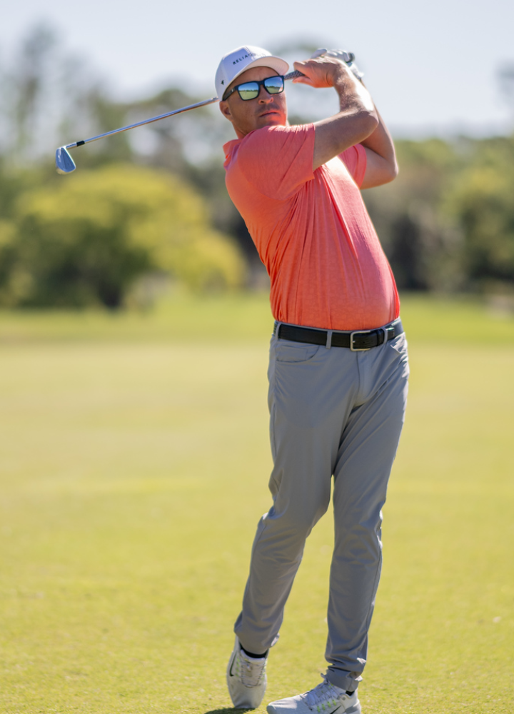 Kevin Roy hitting an iron shot in RIA golf sunglasses 